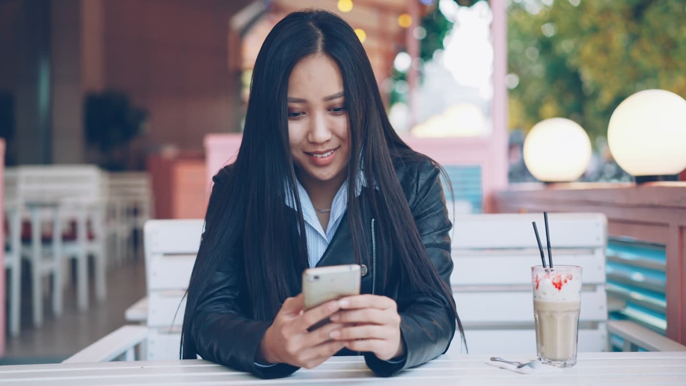 Patiente souriante lisant un message sur son téléphone